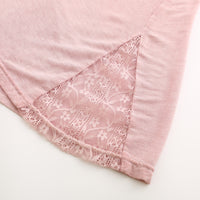 Túnica femenina de encaje elástico, suave y ceñida, con textura de lavado.